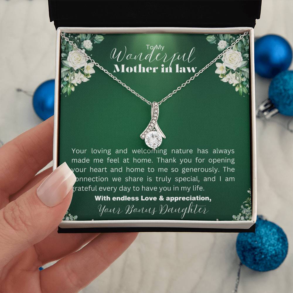 Necklace with a heartfelt message to a mother-in-law in a beautiful gift box, hold by a woman hand in christmas decoration