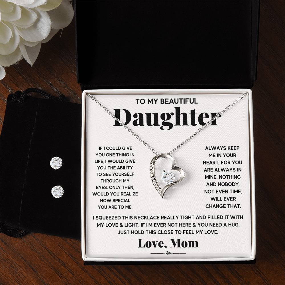 A silver heart necklace set in a black gift  box with a sweet message for a daughter.