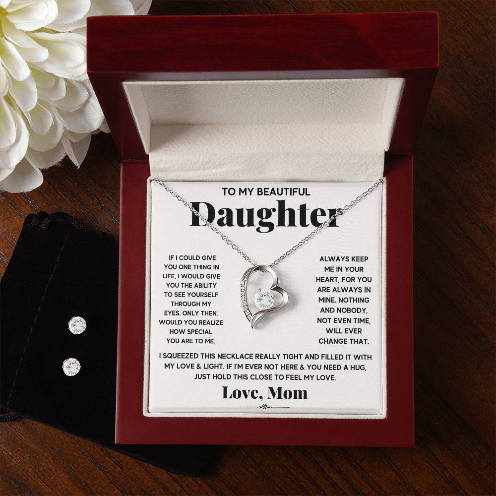 A silver heart necklace in a box with a heartfelt message from a mother to her daughter, emphasizing love and the daughter's specialness.