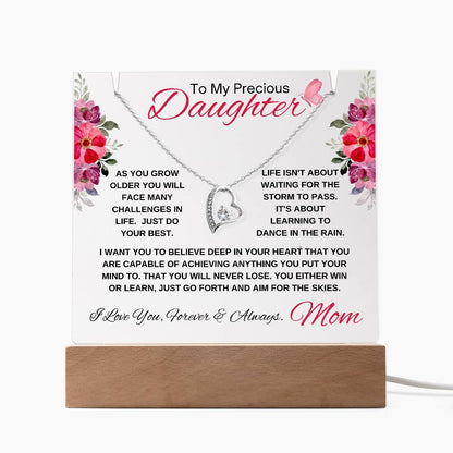 Inspirational message on acrylic plaque for a daughter with a heart necklace. In white background