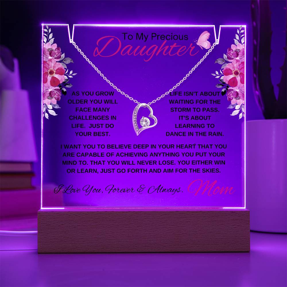 Glowing acrylic plaque with encouraging quote for a daughter on a wooden display.